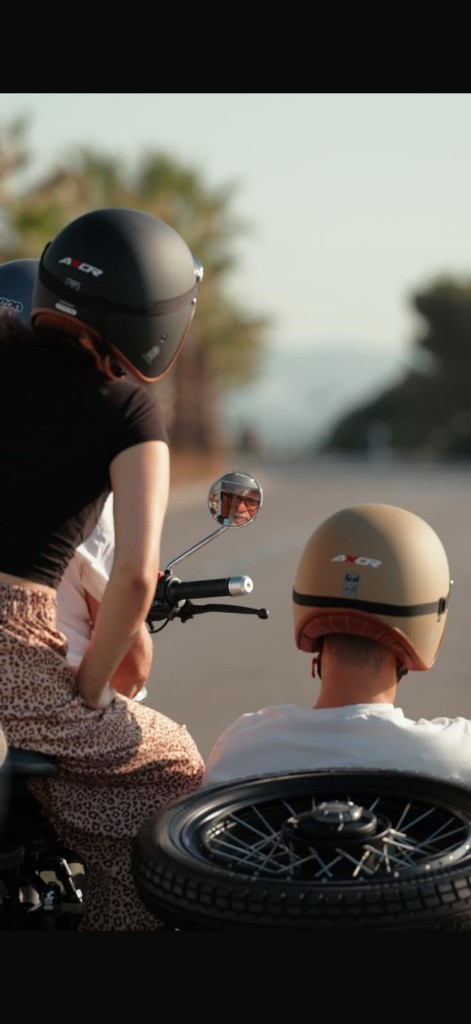 Two guests on a vintage sidecar looking down the open road at golden hour