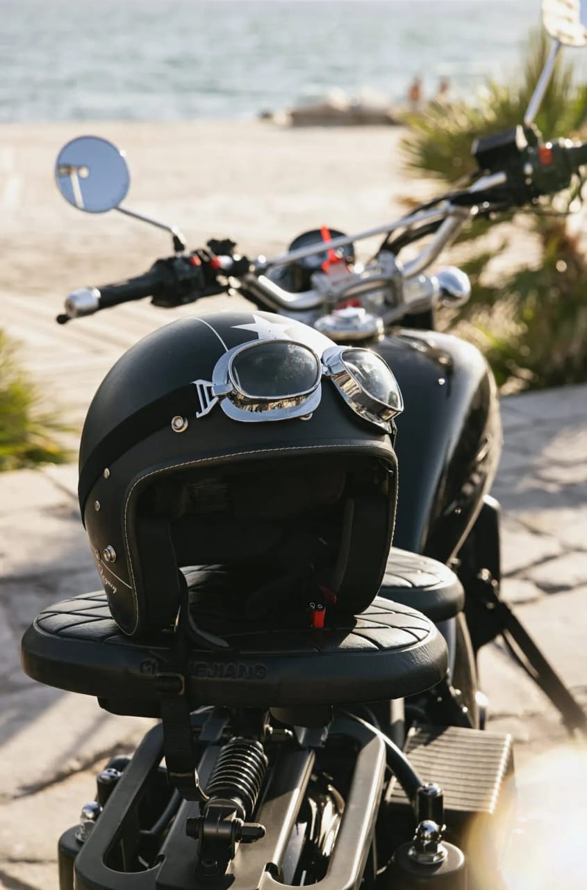 Vintage sidecar helmet resting on the seat with the sea of Rhodes behind